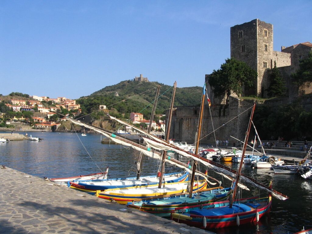 Barques de pêcheurs traditionnelles en bois amarrées dans la baie de Collioure, au pied des remparts du Château Royal