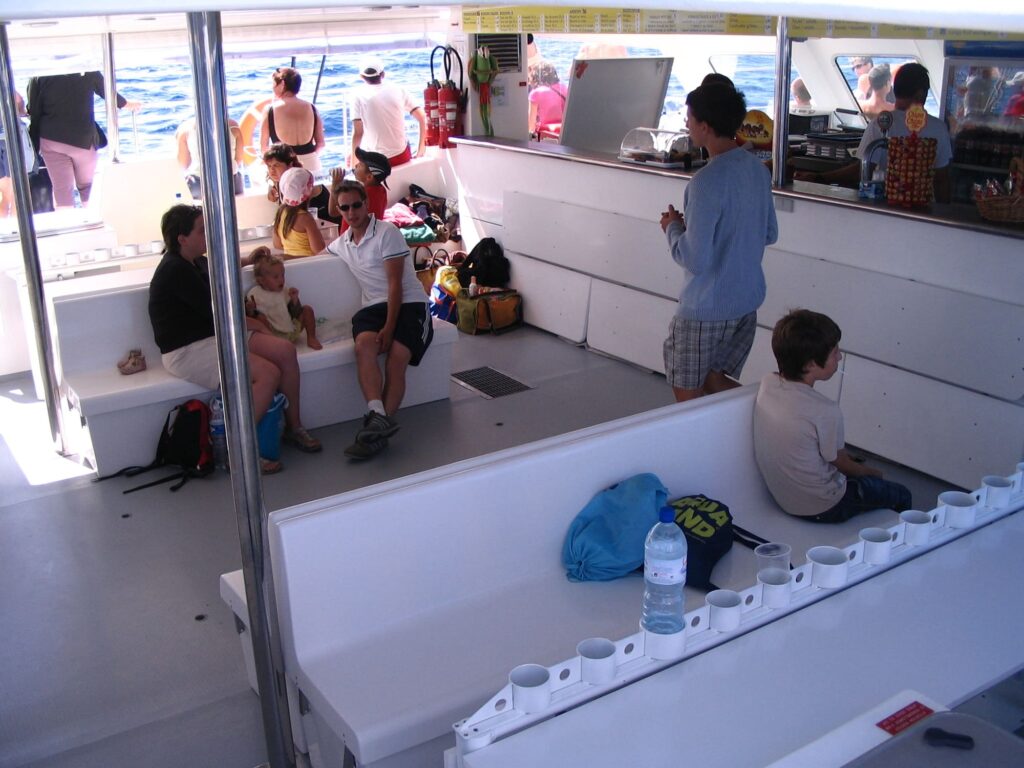 Passagers profitant d'un rafraîchissement au snack-bar à l'intérieur de la nacelle spacieuse du Navivoile pendant une croisière